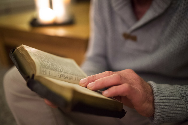 the wooden rosary on the open Bible