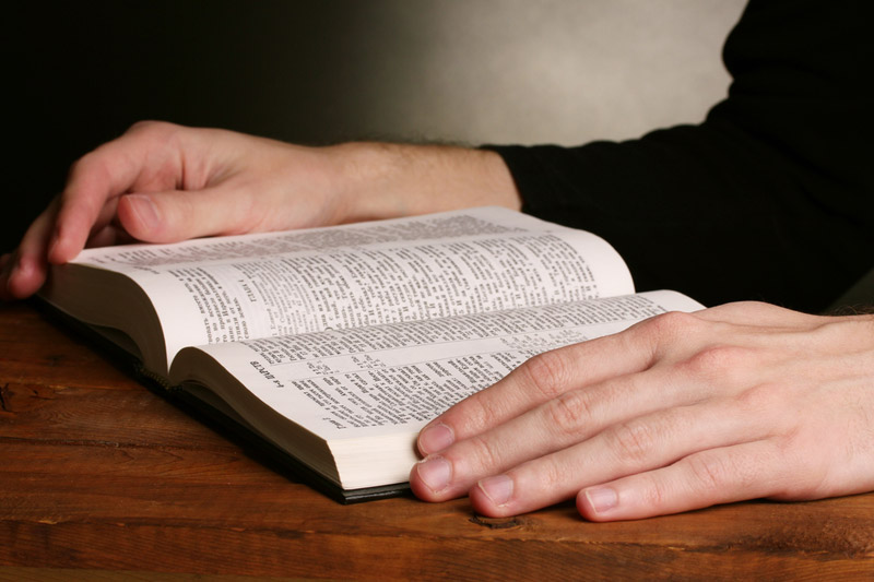 the wooden rosary on the open Bible