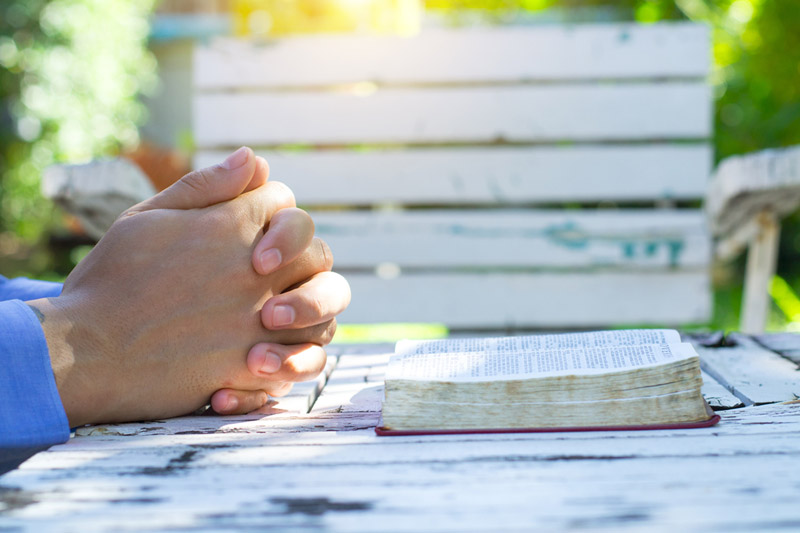 the wooden rosary on the open Bible