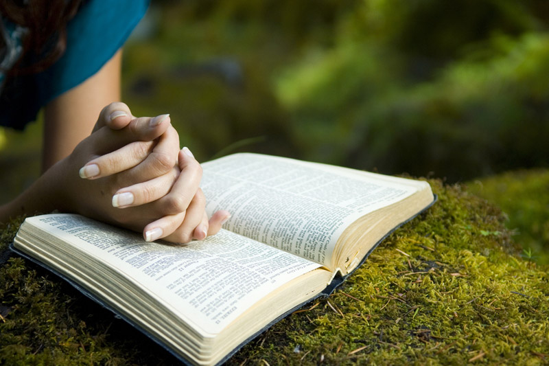 the wooden rosary on the open Bible