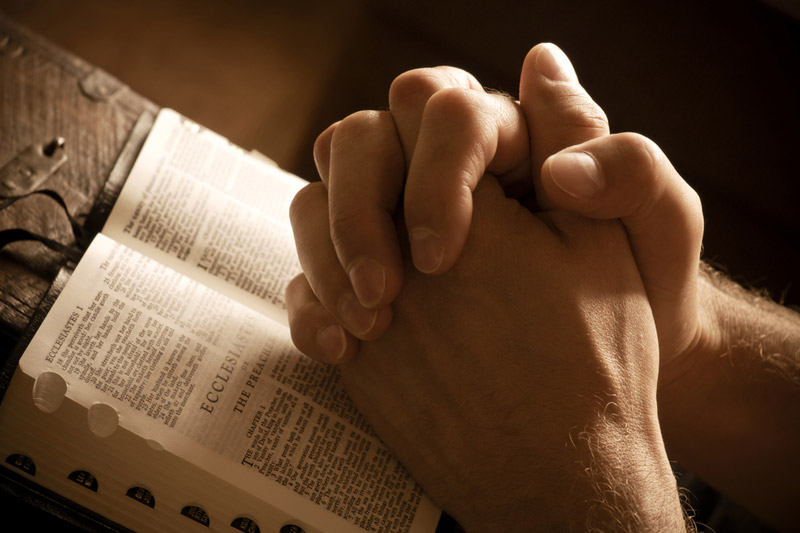 the wooden rosary on the open Bible