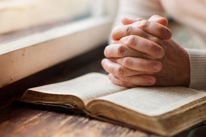 the wooden rosary on the open Bible